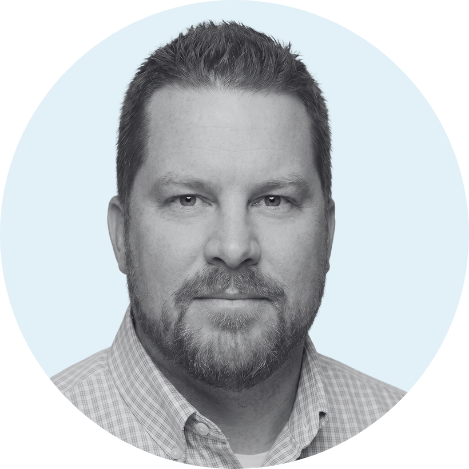 Justin Bell Headshot in Grayscale with light blue background